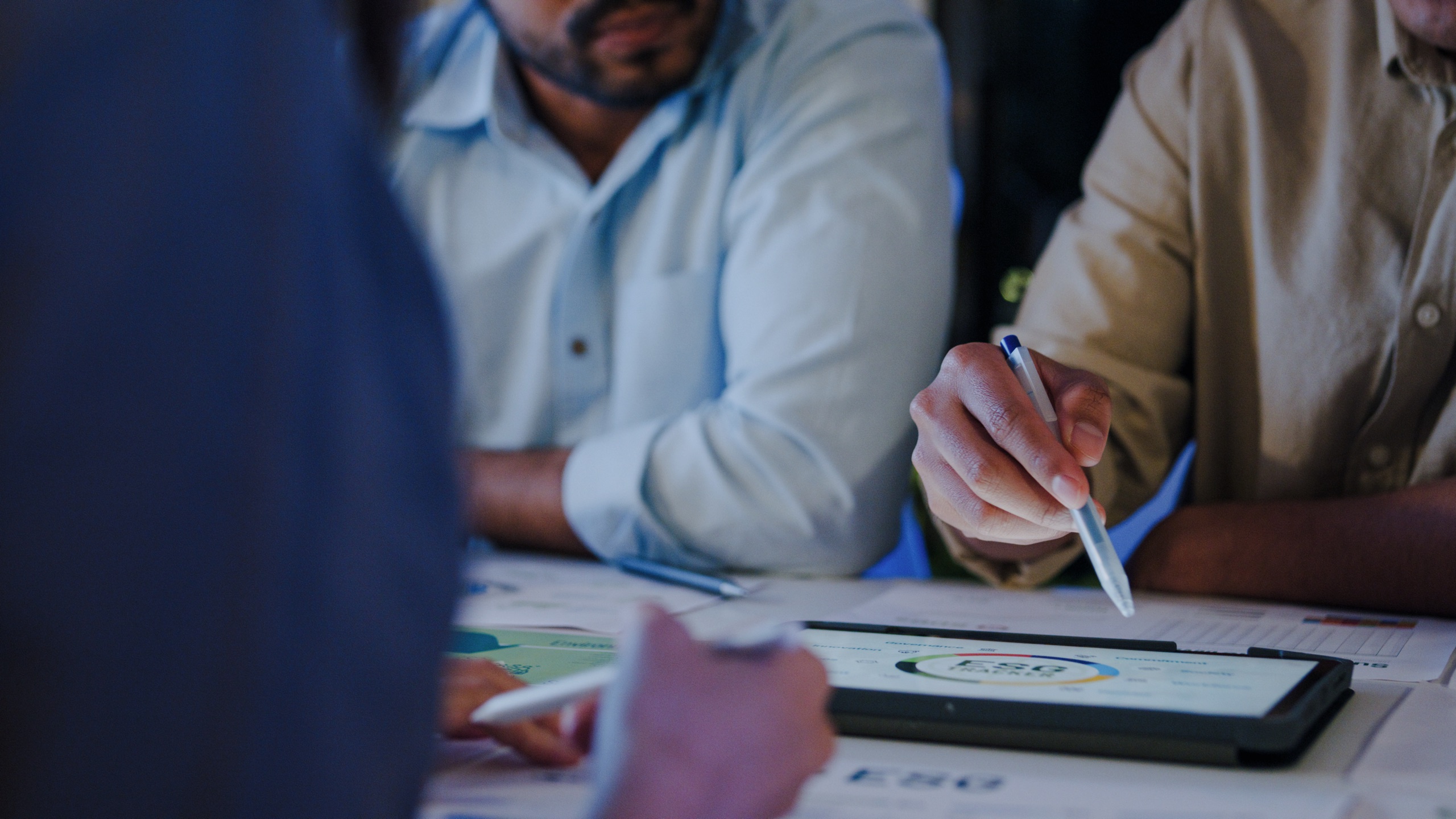 Executives reviewing risk and governance documents around a boardroom table.